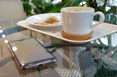 玻璃桌上的脏盘子一个咖啡杯和一个盘子图片