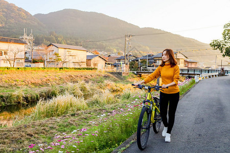 青年妇女骑自行车在日本OitaOitaYuf图片