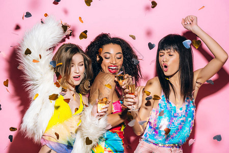 流行时尚的多文化女孩带着香槟杯跳舞用粉图片