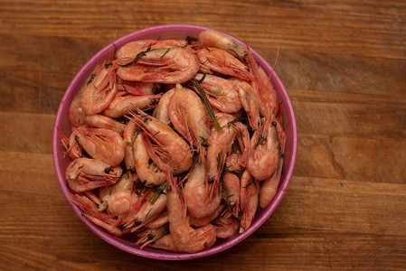 虾煮好的虾放在盘子里在厨房的木板上煮虾放在粉红色的塑料盘子里图片