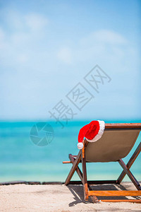 圣诞老人在海滩休息者身上戴圣诞礼帽背景图片