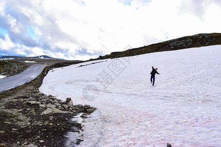 旅游男子在Aurlandsvegenf243旅游雪路附近扔雪球图片