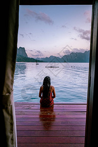 泰国金沙岛在泰国高索湖漂浮的平房前看日出的女人背景