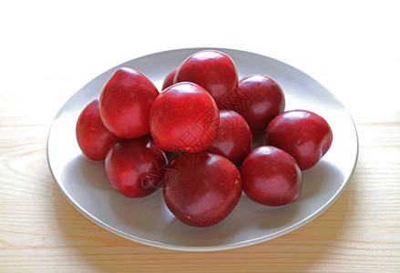 新鲜的海湾鲁比普拉姆水果在木质餐桌上的背景图片