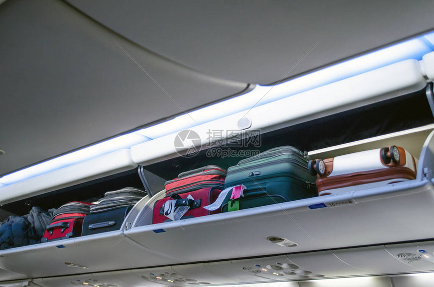 飞机上装满随身行李和行李的头顶行李箱高清图片下载正版图片506380477摄图网