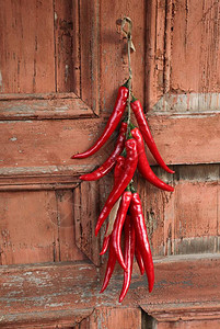 挂着红色热辣椒被拍照的背景是一堵旧的红色的图片