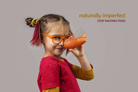 戴着眼镜的小头发怪异的孩子拿着畸形的错误颜色的水果和蔬菜图片