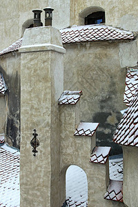 在雪地里用红瓦盖着屋顶的近景图片