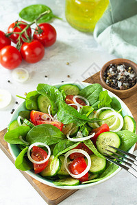 新鲜番茄黄瓜洋葱和菠菜的蔬菜健康沙拉图片