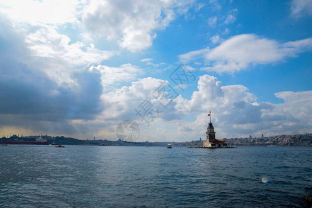 夜晚的灯塔Maiden塔或KizKulesi与漂浮旅游船一起在伊斯坦布尔的Bospho背景