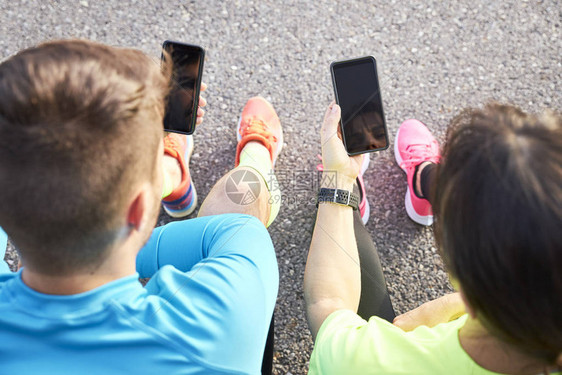 两对跑者用手机分享他们的运行数据运行概念运动培训图片