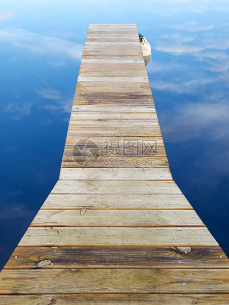 木码头浮桥木码头在蓝色的水反射图片