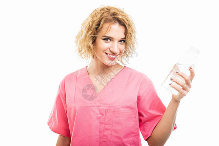 护士穿戴粉红色清洗剂手持白底孤立的一瓶图片