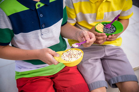 特写冰淇淋两个孩子的手美味的夏日痴迷概念快乐的年轻英俊时髦男孩图片