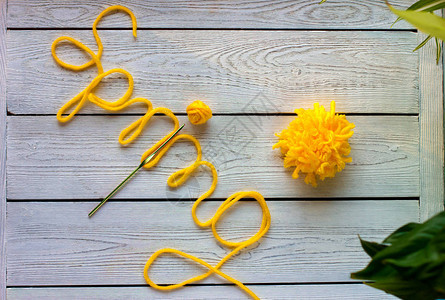 字母弹簧由针织纱钩针和黄色纱球制成针织的春天颜图片