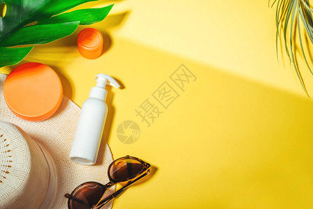 防晒物品带太阳眼镜和保护霜spf30顶视图的稻草女人帽子在明亮的黄色背景上海滩配件夏季旅游度假概念销售套图片