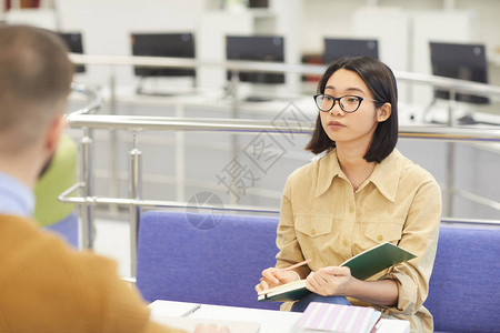 亚裔年轻女在大学图书馆学习的肖像图片