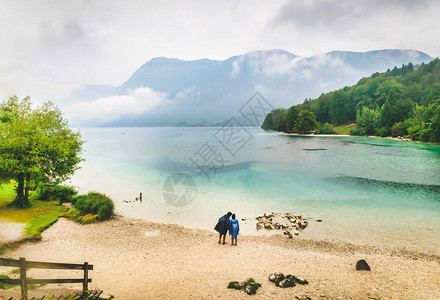 男女站在Bohinj湖旁在图片