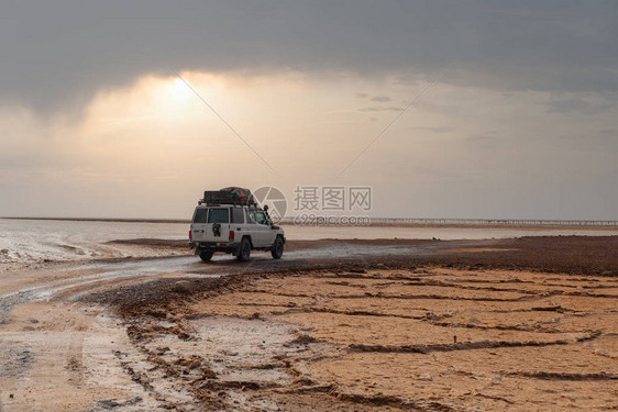 埃塞俄比亚达纳基尔洼地盐湖上的越野探险车达纳基尔沙漠是地球上最低和最图片