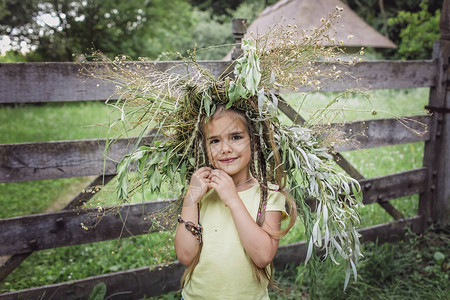 可爱的78岁女孩在乡间别墅后院戴着美丽的夏花金色小麦和绿草花环图片