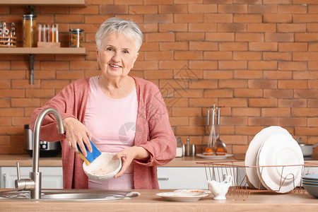 在厨房洗碗的老妇人图片