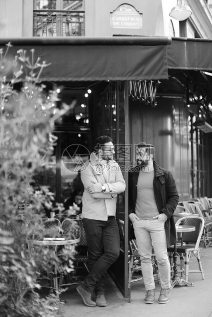 两个白人男子站在街边咖啡馆聊天的黑白照片友谊和朋图片