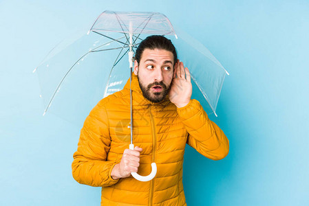 穿着长头发的年轻人拿着一只孤立的雨伞试图片