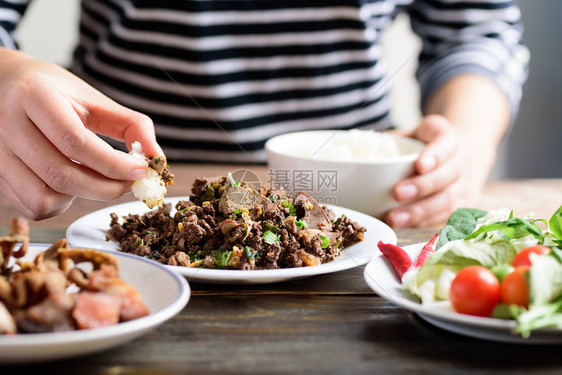 北泰国食品辣薄煎猪肉沙拉LarbMooKua用手食用粘糊饭烤图片