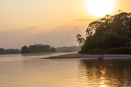 在乘船旅行期间亚马逊雨林日落与水中树木的倒影弗朗西斯科德奥雷利亚纳港厄瓜背景图片
