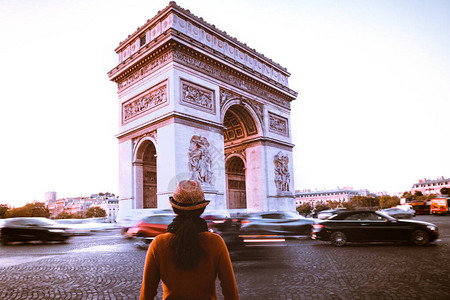 巴黎街上的凯旋门和旅行者在黄昏时分图片