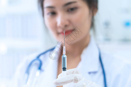 美丽的女医生和疫苗剂量流感注射药物注射器在医院图片