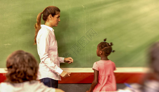 小学的非洲女孩教师站在绿色黑板前掌声图片