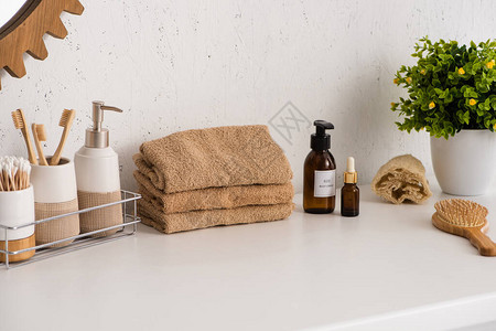卫生用具在毛巾美容产品和浴室花盆附近的架子上图片