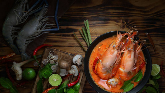 Tomyumgoong的顶部景色泰国传统食物和大虾黑碗热辣汤和木桌图片