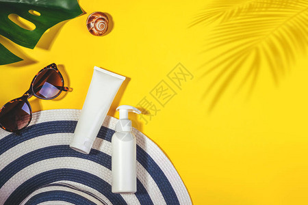 防晒物品带太阳眼镜和保护霜spf30顶视图的稻草女人帽子在明亮的黄色背景上配件夏季旅游度假概念销售套图片