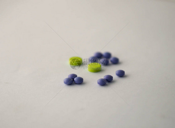 白纸背景上的药片绿色和紫罗兰色图片