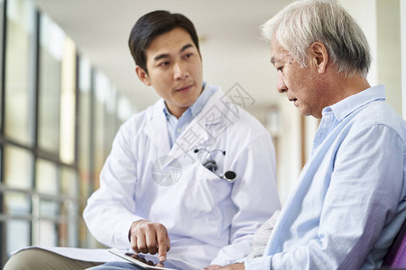 年轻的亚洲医生在医院向老年患者谈话和图片
