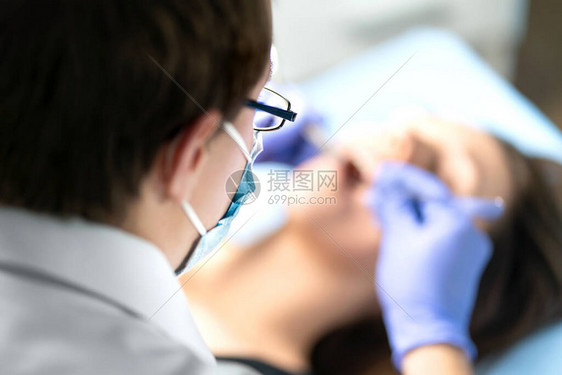 牙医或牙科保健员与患者一起手术有结石或龋齿的女人口腔医生去除智齿牙科专人操作与正畸医生或牙科图片