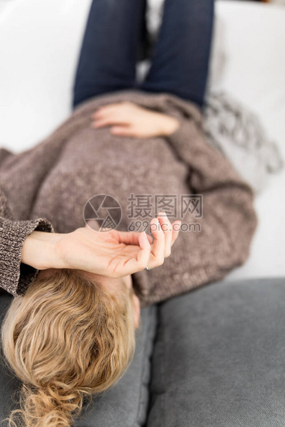 疲劳的精疲力尽的女人在家沙发上有问题图片