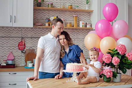 餐桌上的一家人拿着生日蛋糕和气球图片