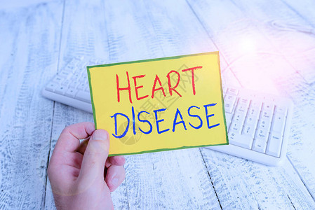 手写文本心脏病涉及心脏或血管的概念照片类疾病男子手持彩色提醒方形纸图片