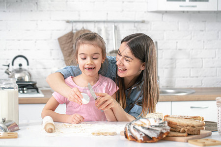 快乐的家庭妈和女儿在厨房准备糕点一个充满爱的家庭和家庭价值观的概念健图片