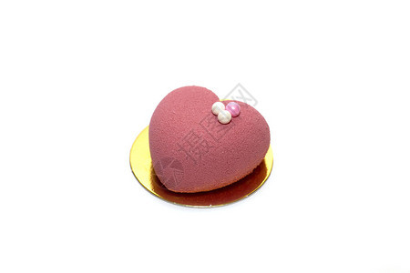 一个粉红色的心形蛋糕上面装饰珍珠孤立图片