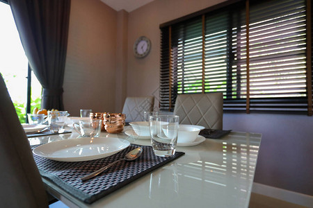 现代家居室内餐厅内餐桌上的玻璃水和餐具套装背景图片