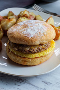 香肠鸡蛋和奶酪早餐三明治在英式松饼上图片