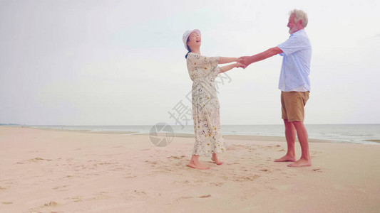 幸福的情侣在沙滩上站在一起手牵图片