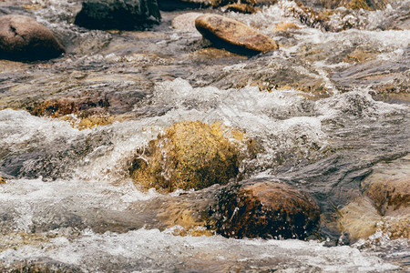 岩床的溪流岩石之间的快山河水在洋流图片