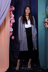 亚洲女长直发白衬衫黑色裤子灰色外套站在粉色玫瑰花上的时尚姿势图片