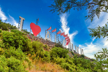 公共园中阿拉尼亚市名称的爱情符号和字母以及城市景观图片