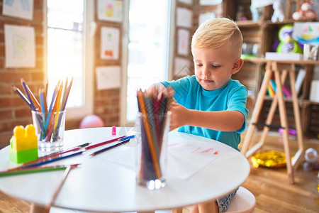幼稚的天主教儿童在幼儿园用彩色铅笔绘画图片